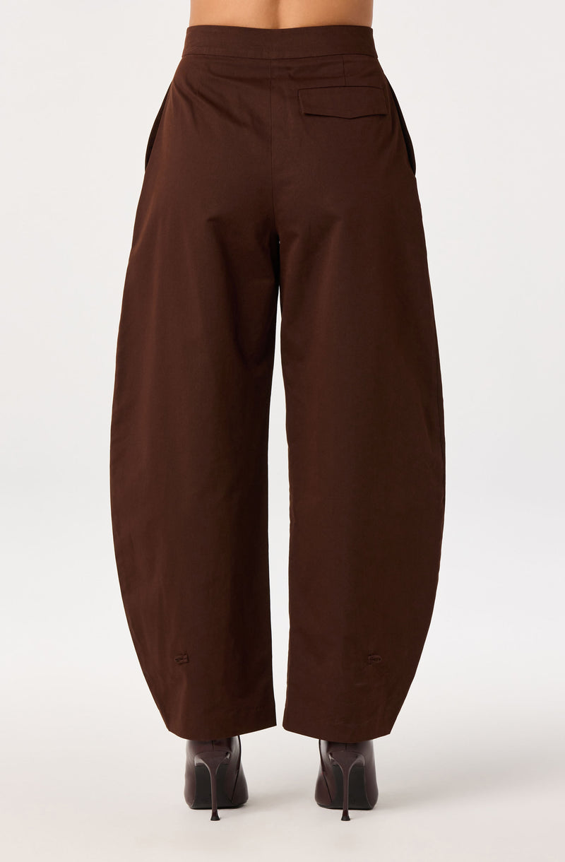 Brown wide-leg trousers with high waist and back pocket, worn with gray high heels.