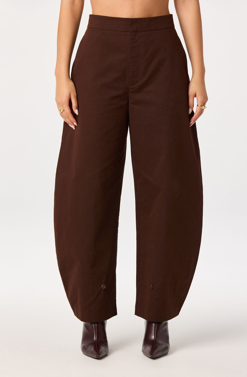 High-waisted brown wide-leg pants with ankle buttons, paired with brown ankle boots.