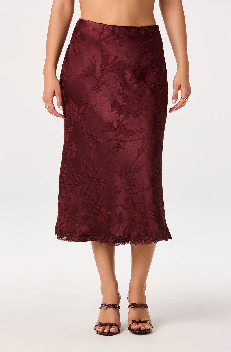 Long burgundy satin skirt with floral embroidery and scalloped hem.
