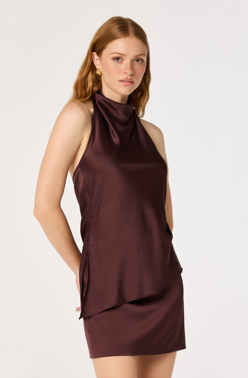 Woman in a sleeveless, satin, burgundy high-neck dress.