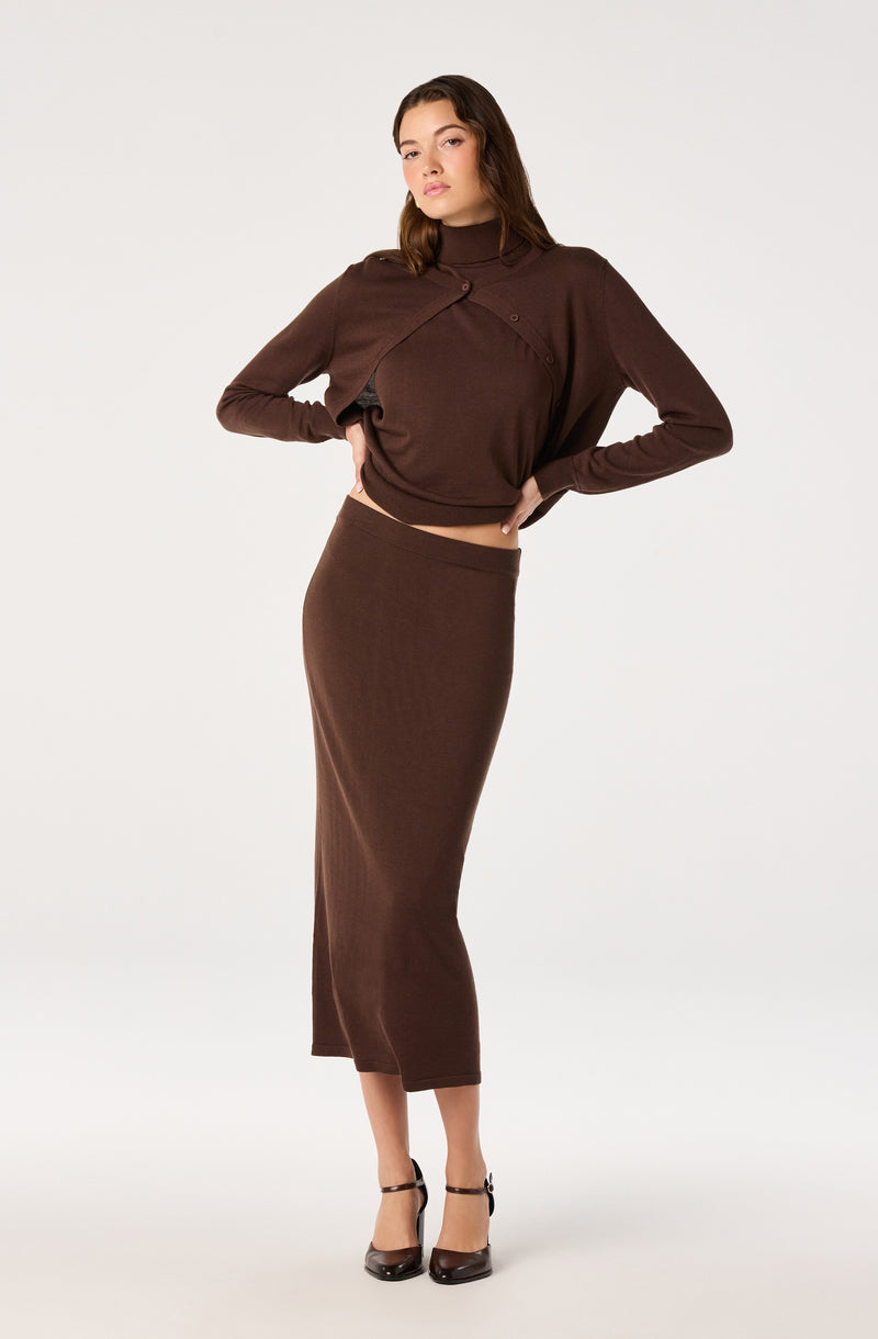 Woman wearing a dark brown cropped sweater and a matching high-waisted midi skirt.