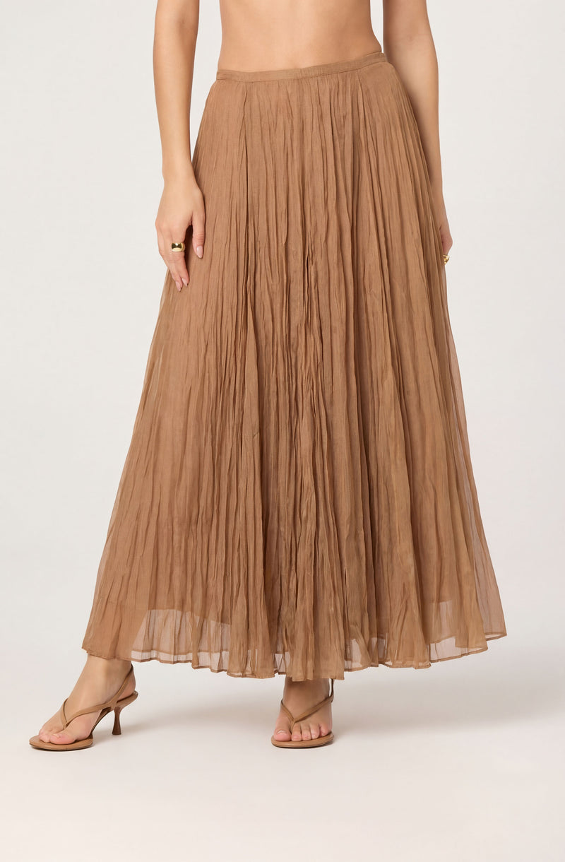 Light brown, pleated, ankle-length skirt with a sheer, flowing fabric.