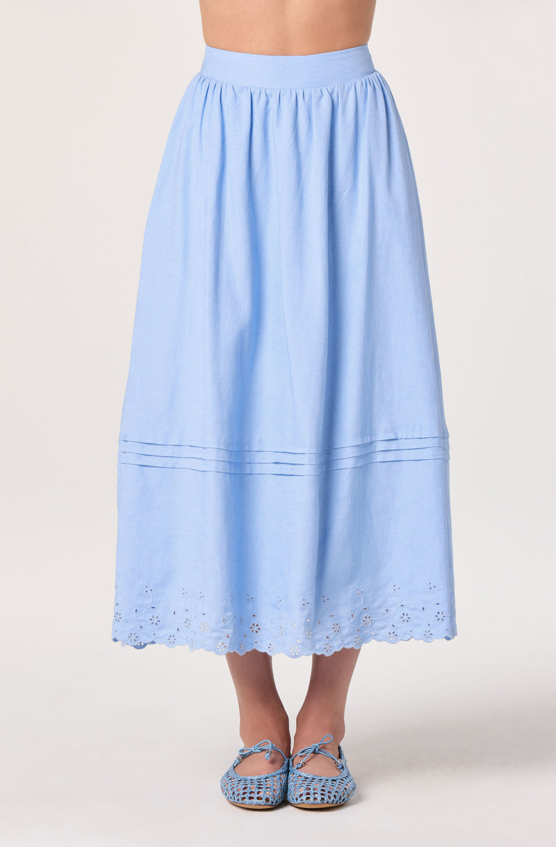 Light blue midi skirt with embroidered hem and lace details, paired with matching shoes.