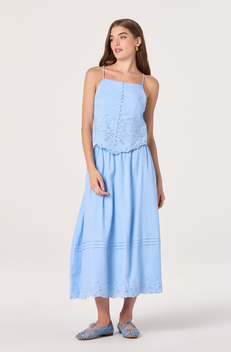 Woman wearing a light blue sleeveless top with eyelet details and a matching long skirt.