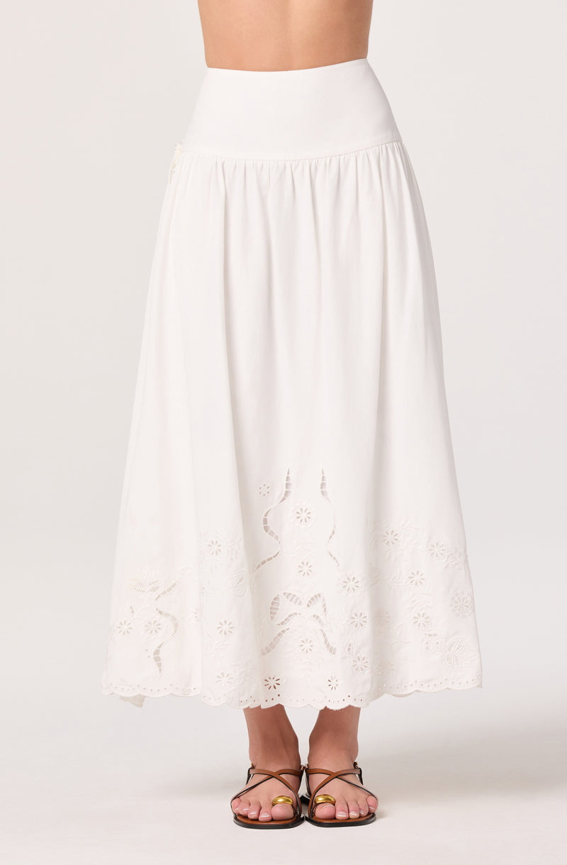 White high-waisted ankle-length skirt with embroidery and cut-out floral patterns.