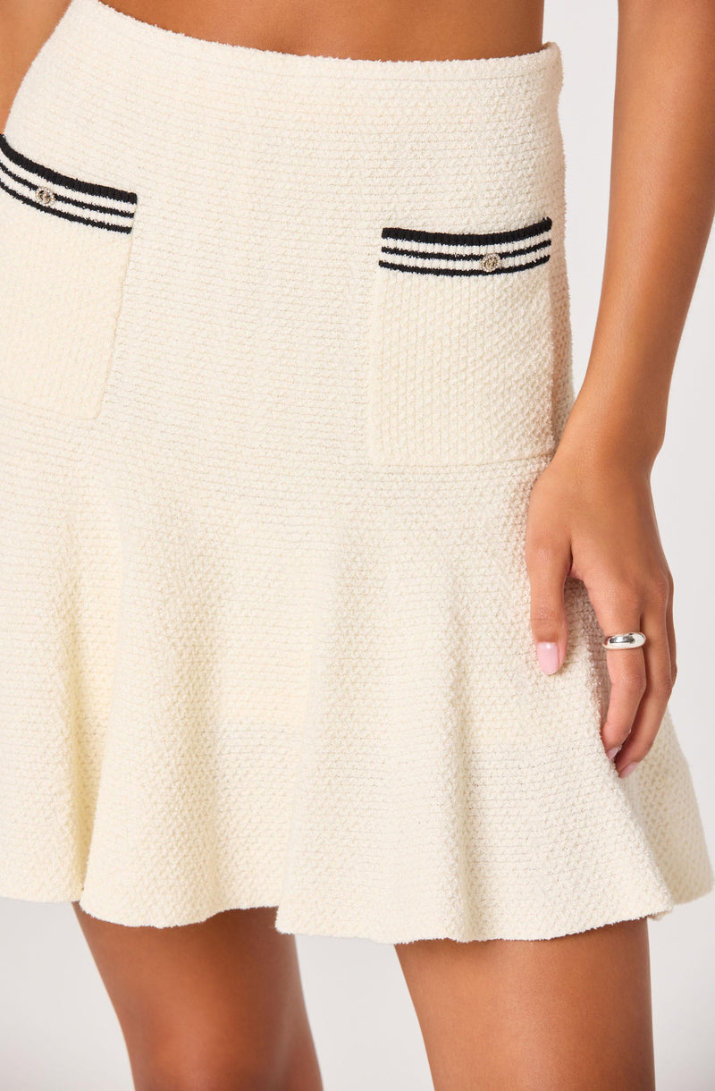 Cream textured skirt with black and white striped details on pockets and waistband.