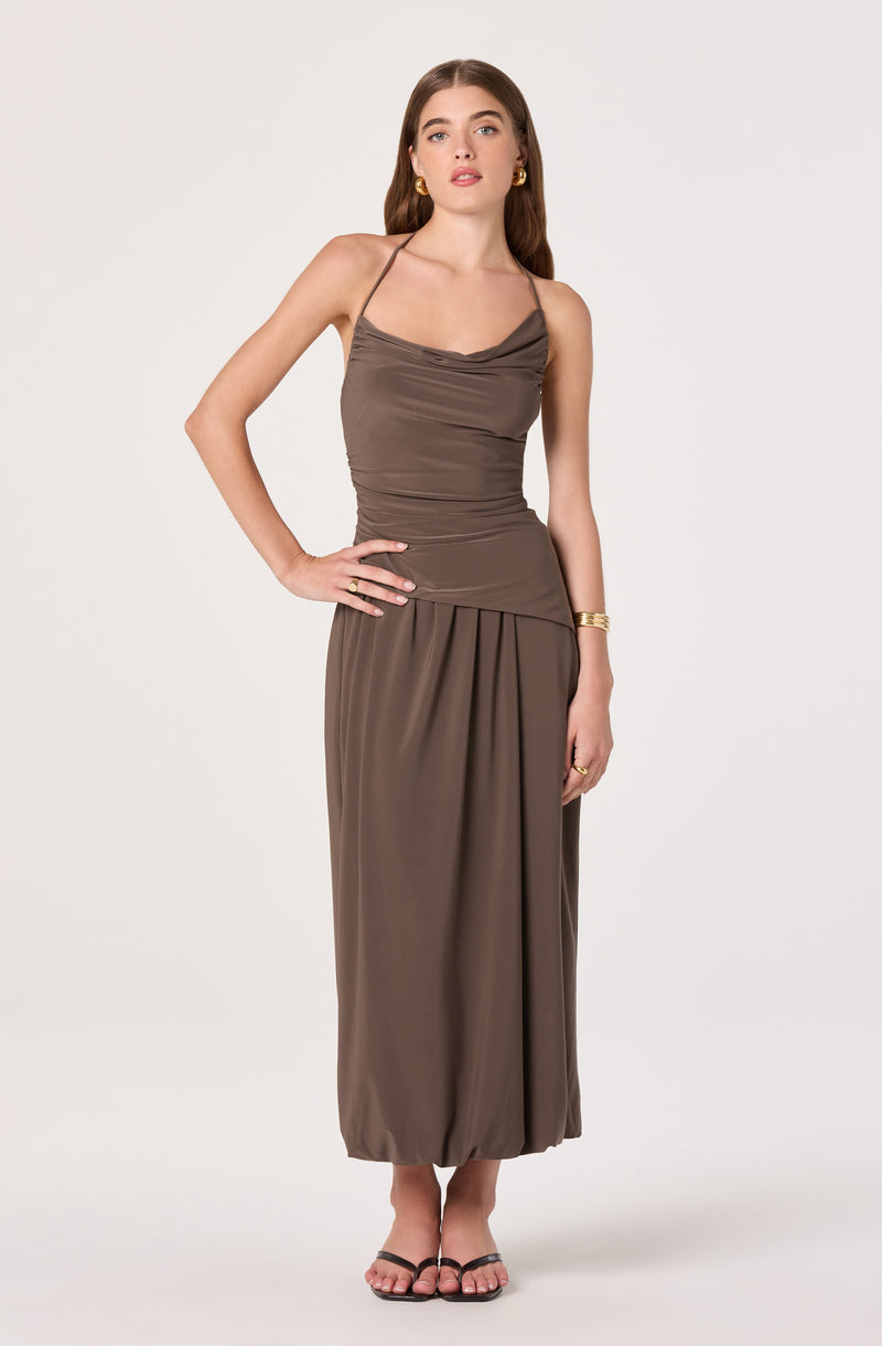 Woman in brown sleeveless dress with spaghetti straps and ruched bodice, wearing sandals.