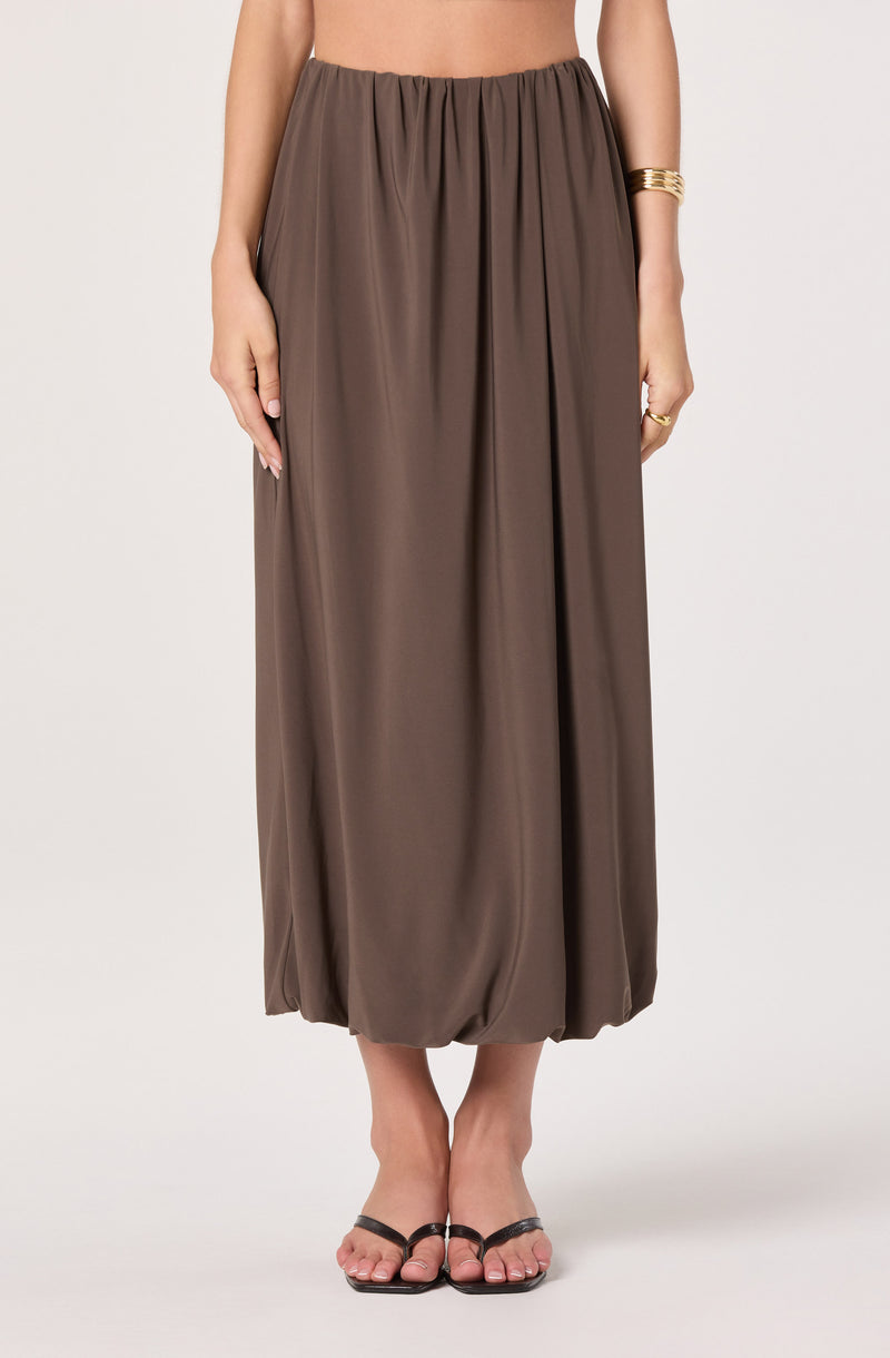 Brown, loose-fitting, ankle-length skirt with elastic waistband and gathered fabric.