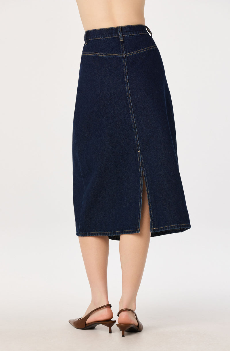 Woman wearing a dark blue high-waisted denim midi skirt with front slit.