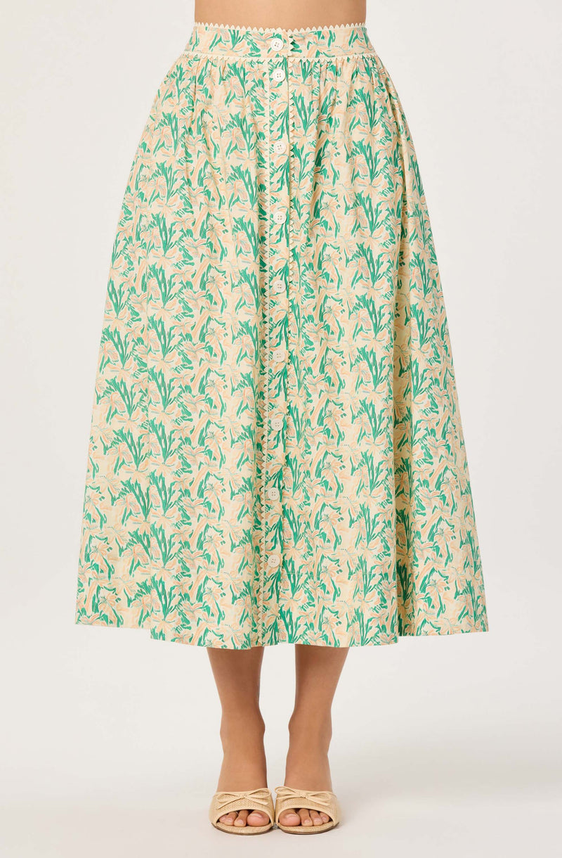 A beige midi skirt with a green leafy pattern, button-front, and elastic waistband.