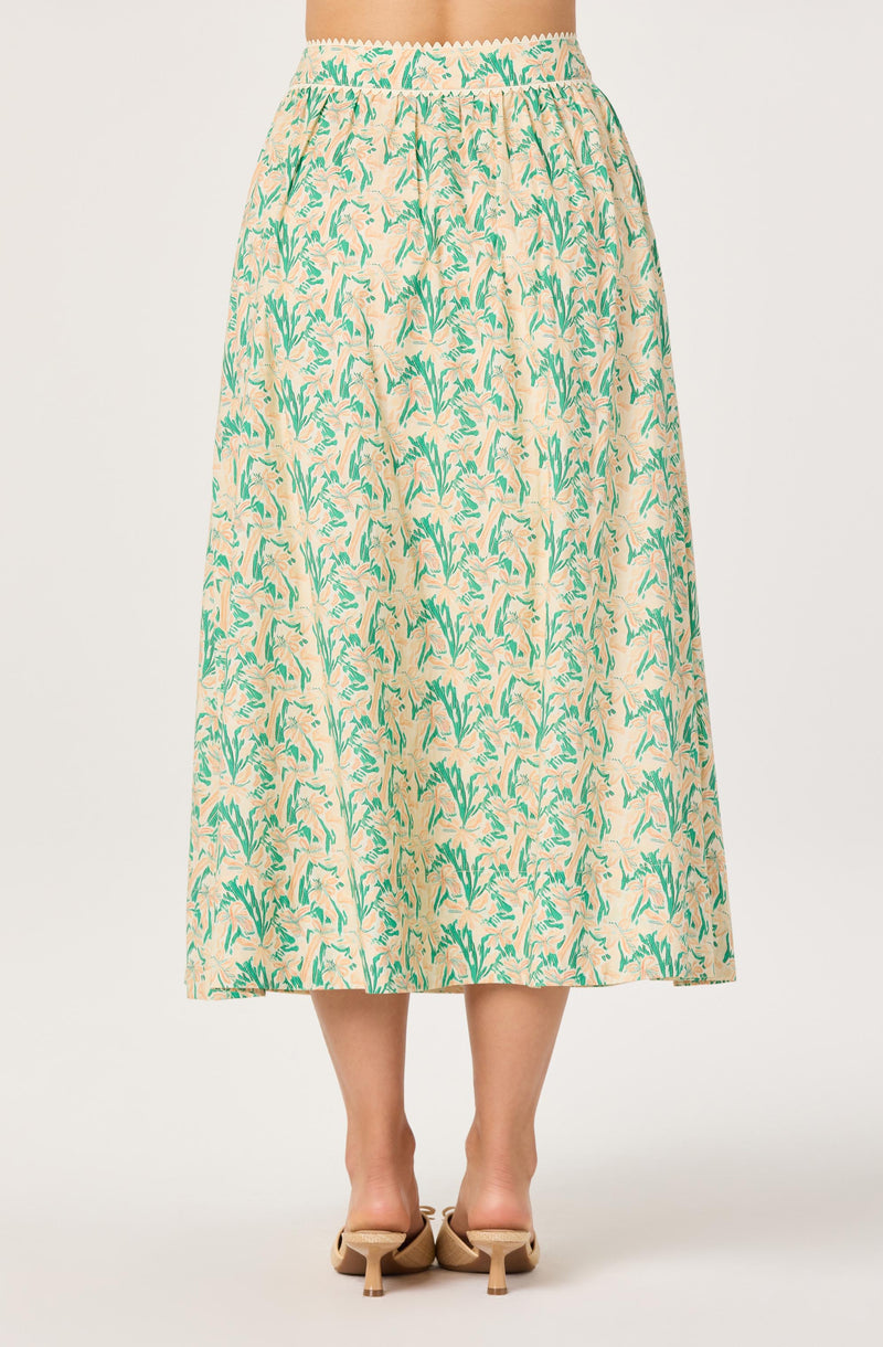 Long beige skirt with green and blue floral pattern, elastic waistband.