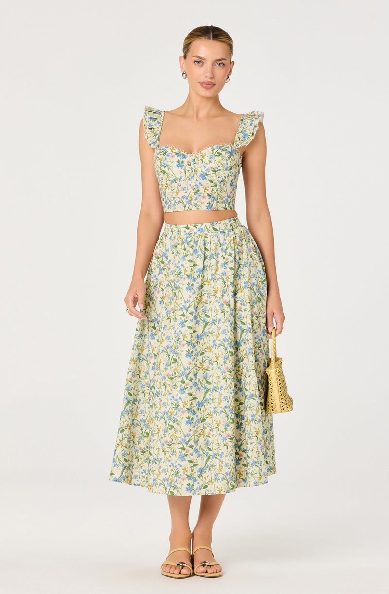 Women wearing a matching floral crop top with ruffled shoulder straps and a high-waisted, ankle-length floral skirt.