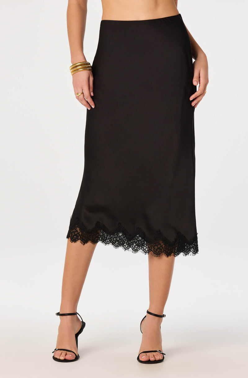 Black midi skirt with lace hem, paired with black high-heeled sandals.