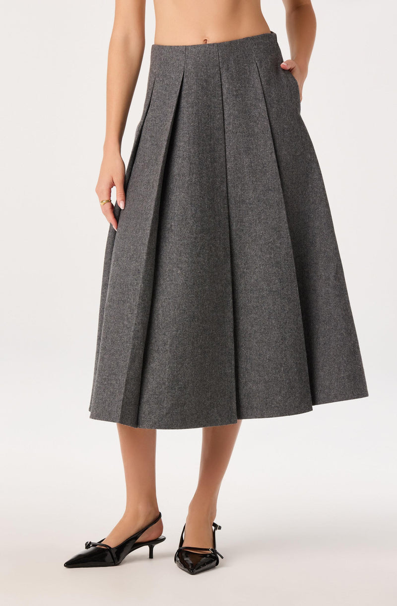 High-waisted, wide-leg gray wool skirt with pleats, styled with black pointed heels.