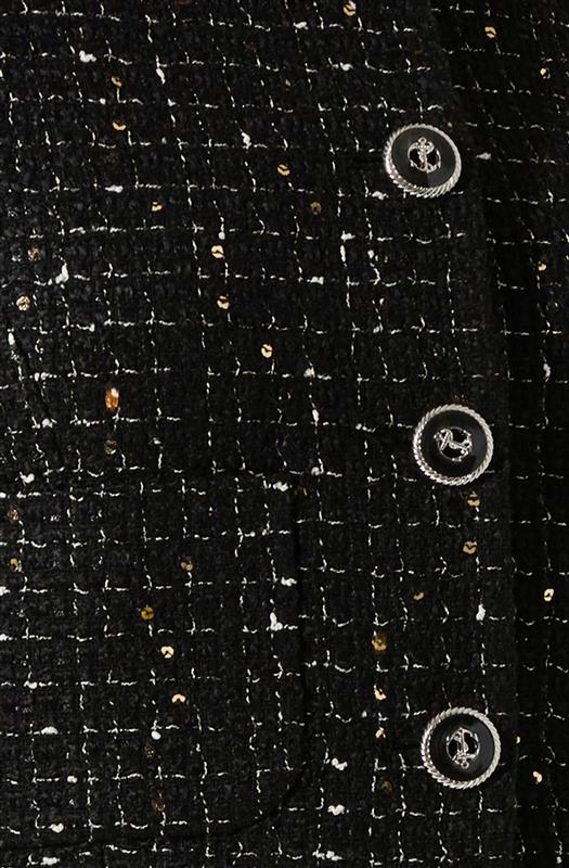 Close-up of a black textured fabric with a woven pattern, featuring three large silver buttons with an anchor emblem. The fabric appears to be part of a garment, possibly a blazer or coat, with a decorative, classic style.