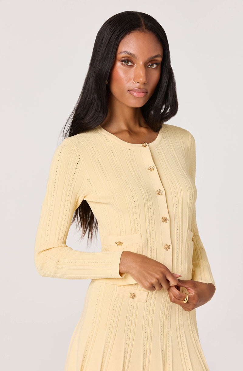 Light yellow knit jacket with gold buttons and matching skirt, fitted style.