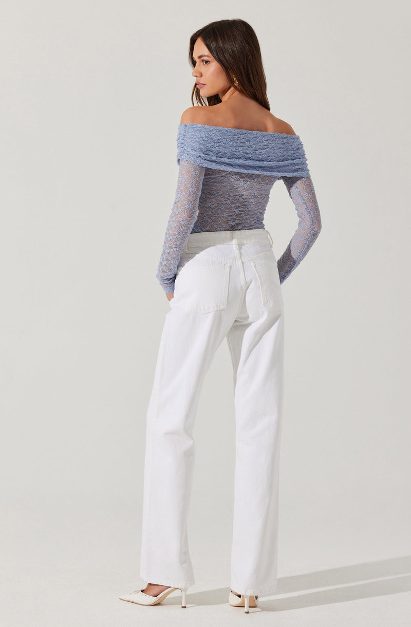 A woman is wearing an off-the-shoulder, long-sleeve top made of a textured, fuzzy fabric in light blue. The top is paired with sheer, fitted lace sleeves that match the lace material of the main body. She is also wearing high-waisted, wide-leg white pants and nude-colored high heels.