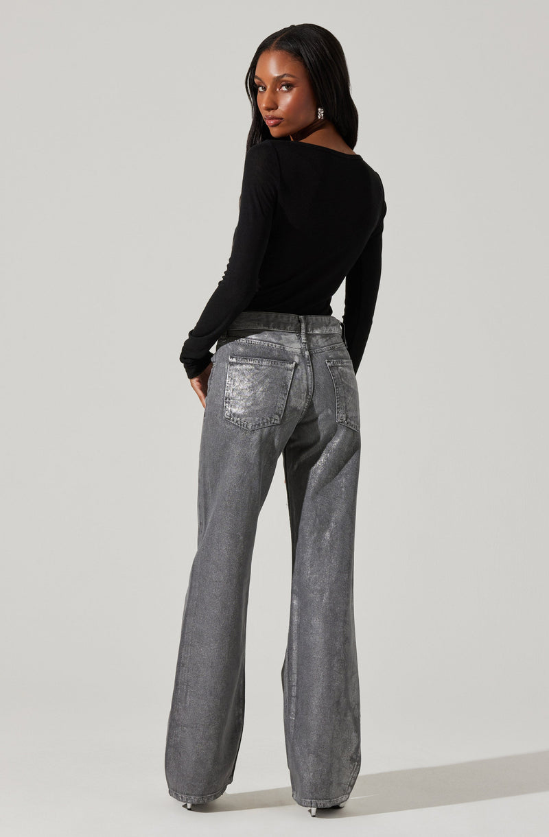 A woman is wearing a fitted black long-sleeve top and high-waisted, loose-fitting gray jeans with a slightly faded and distressed look. The jeans feature large back pockets and a wide-leg cut.