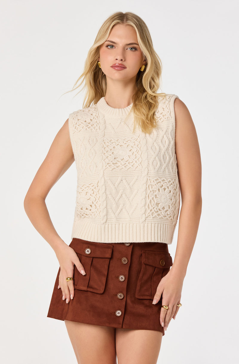 Cream sleeveless knit top with cable and openwork patterns, paired with a brown button-front skirt.