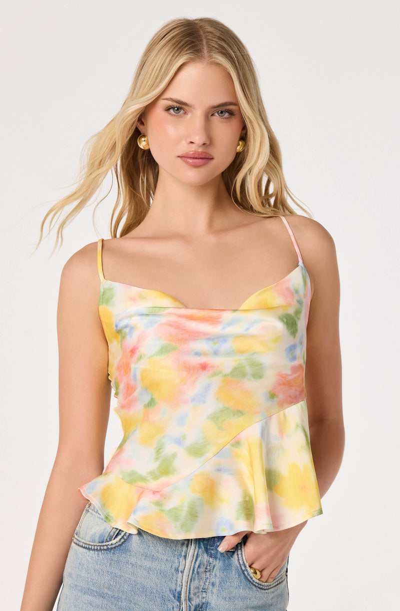 Woman wearing a colorful, tie-dye sleeveless top with spaghetti straps and a ruffled hem.