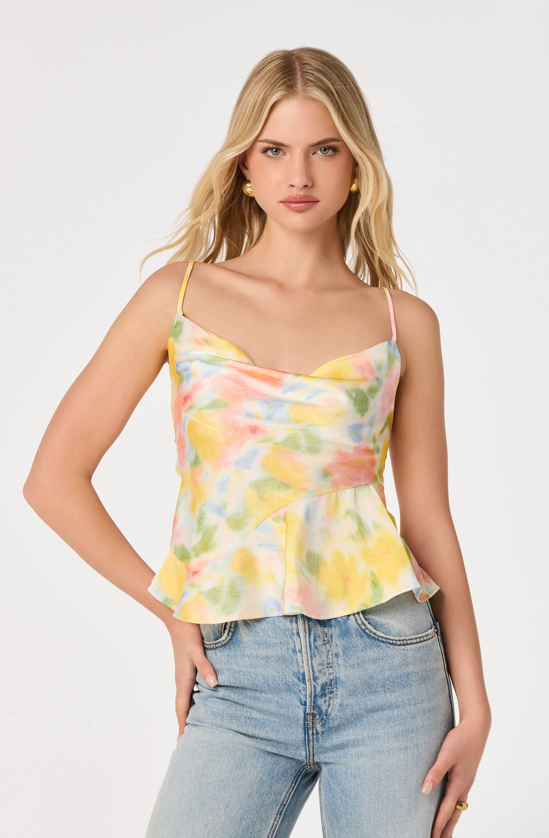 Woman wearing a pastel floral tie-dye sleeveless top with spaghetti straps and a ruffled hem.