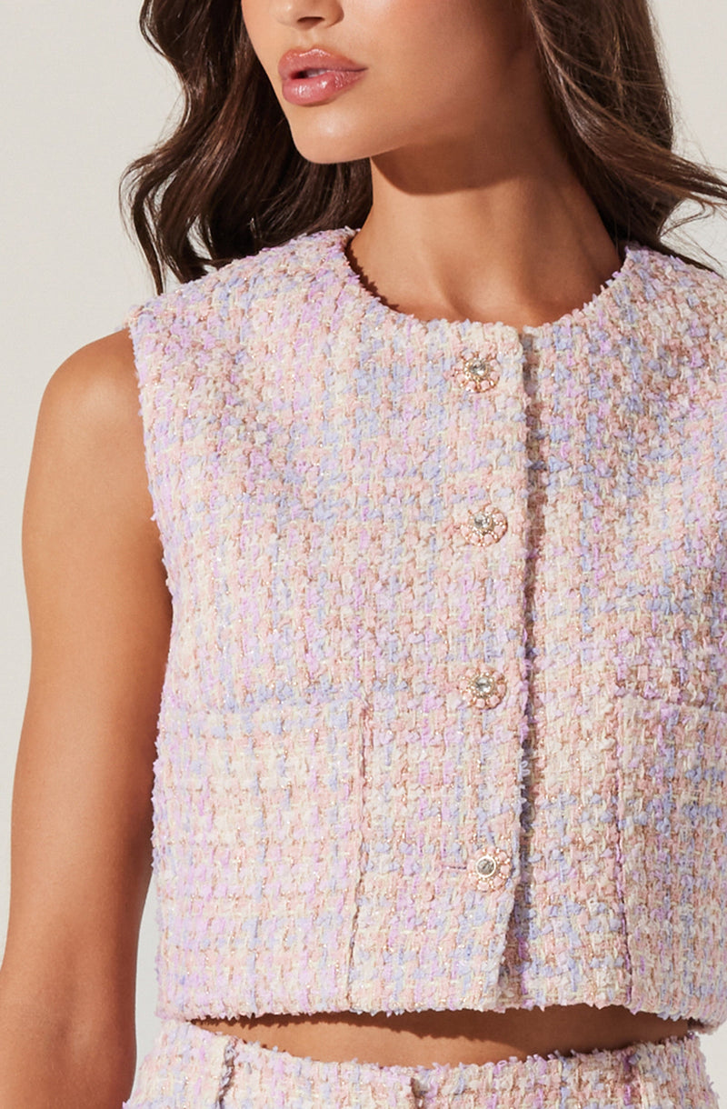A sleeveless, cropped top made of textured tweed fabric in pastel shades of pink, lavender, and cream. The top features a round neckline and a front closure with decorative pearl and metal button details.