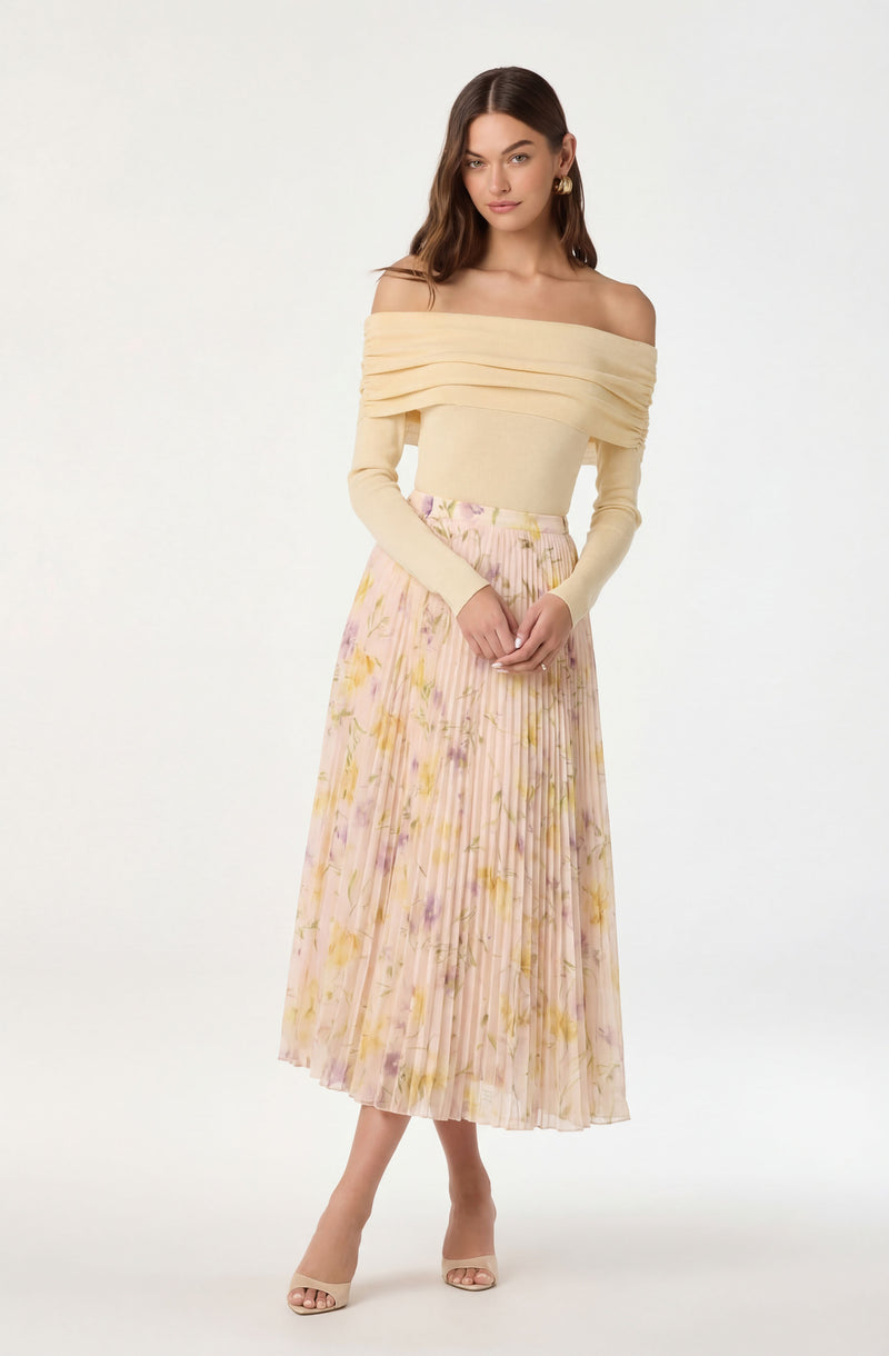 Off-the-shoulder cream sweater avec layered neckline and a pastel floral pleated midi skirt.