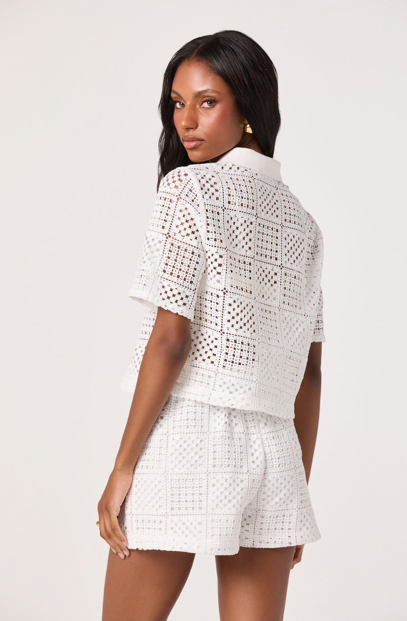 Woman in white crochet top and matching shorts.