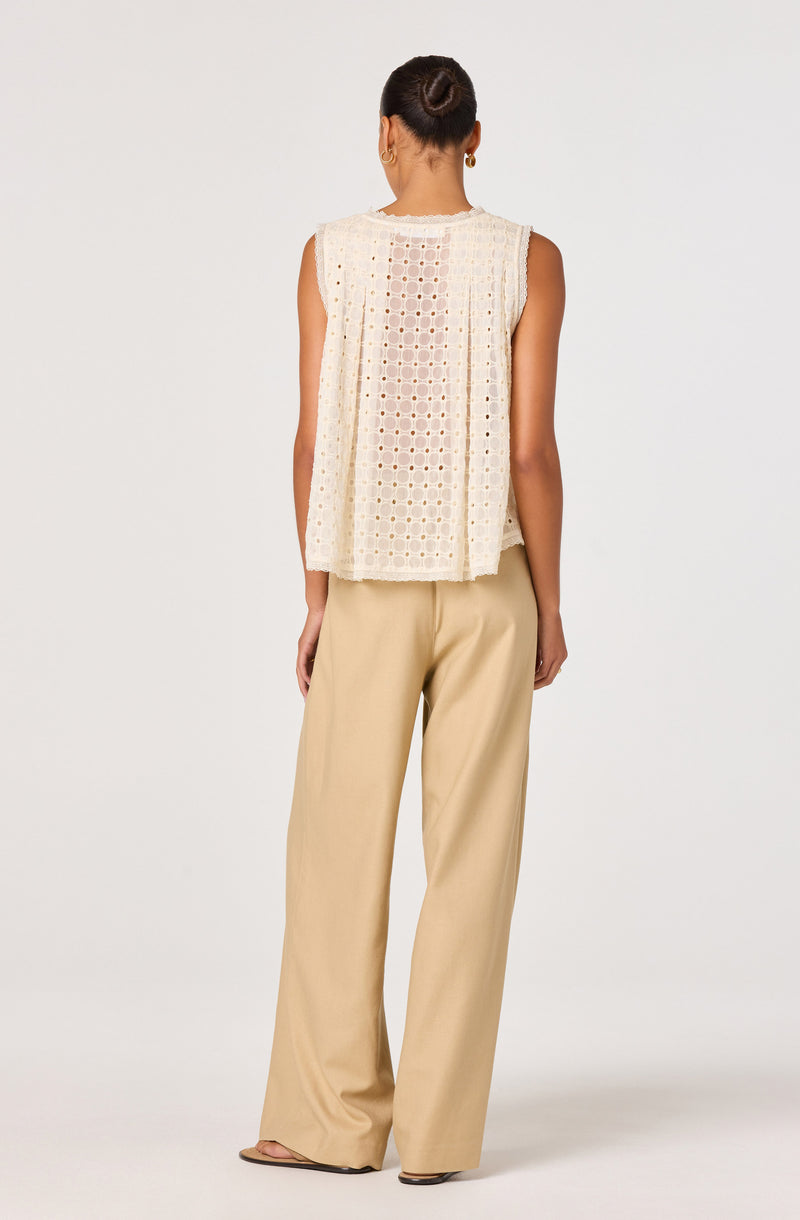 Cream sleeveless crochet top and wide-leg beige pants.