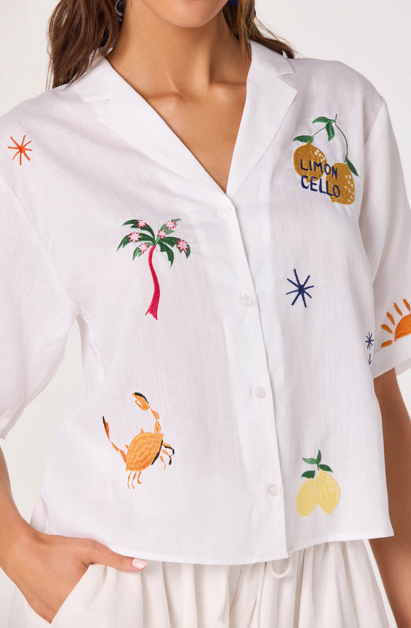 White short-sleeve button-up shirt with colorful embroidered tropical and summer-themed designs.