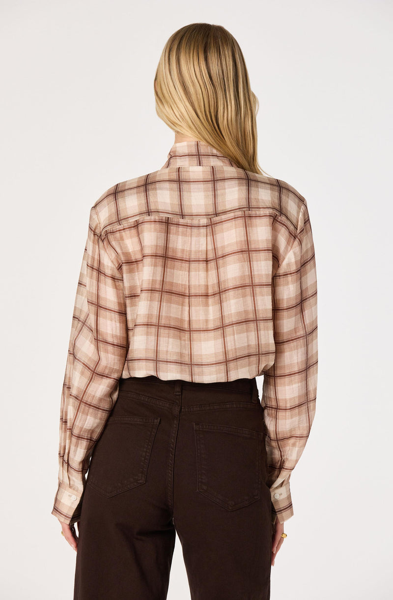 Beige plaid shirt with long sleeves and dark brown high-waisted pants.
