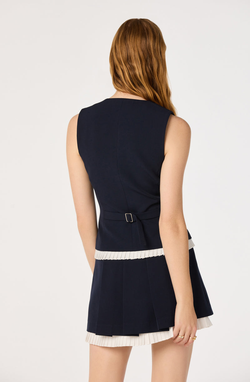 Navy sleeveless top with a waist buckle and matching pleated skirt with white trim.