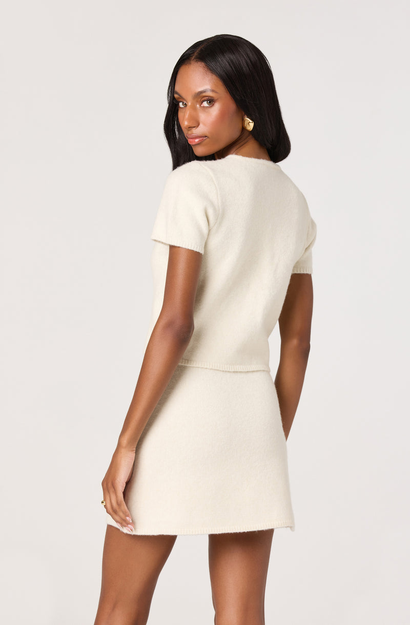 Cream knit short-sleeve top and matching cream knit skirt.
