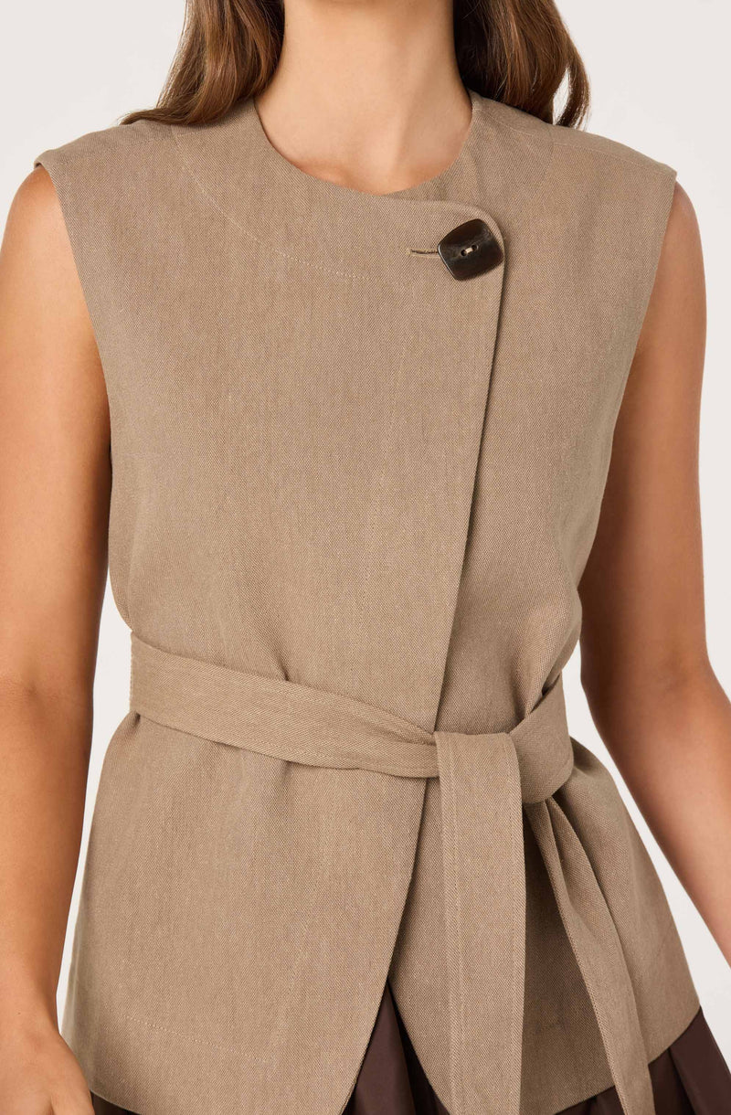 Sleeveless beige vest with a front clasp and a waist tie.