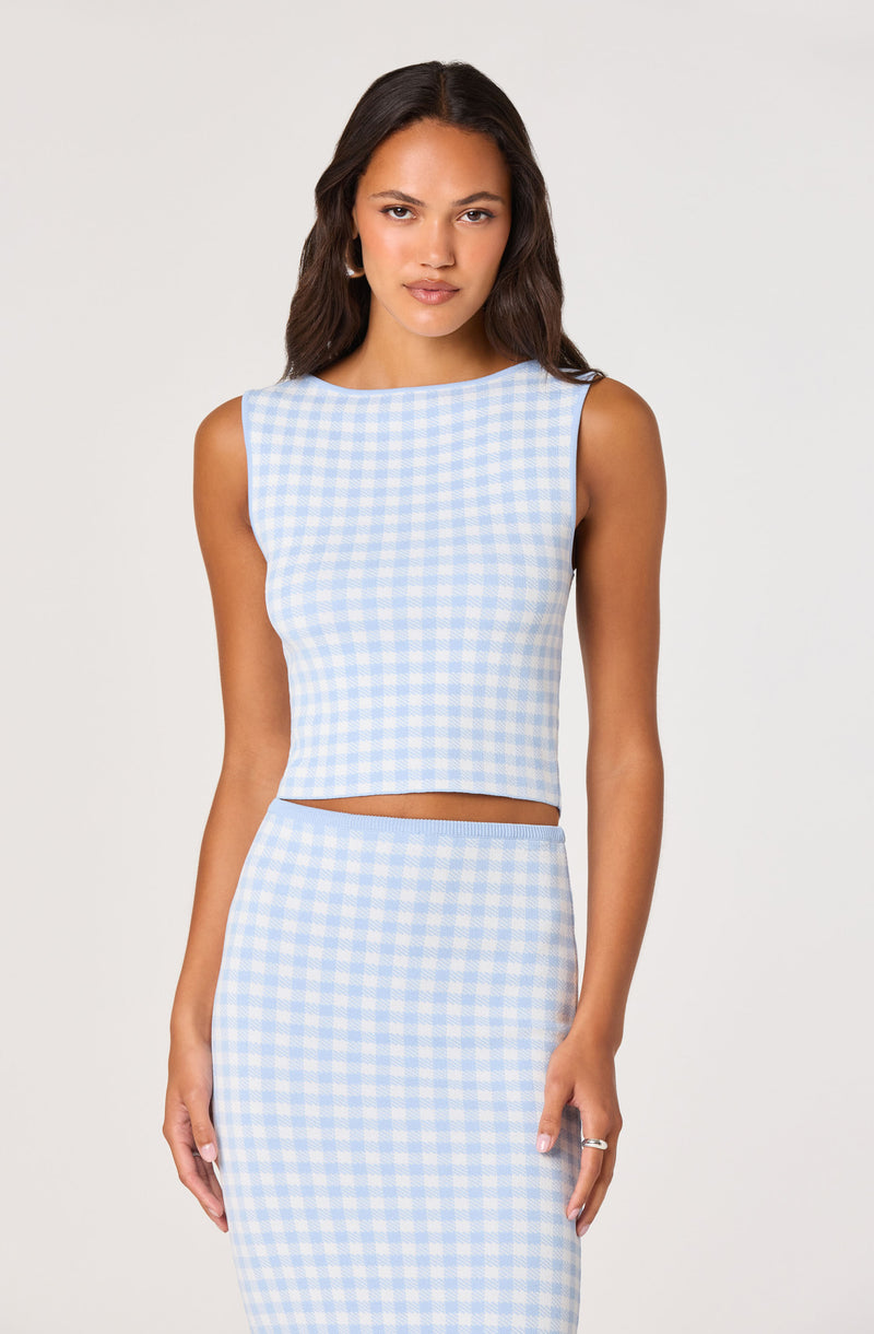 Woman in a sleeveless light blue and white gingham crop top and matching high-waisted skirt.