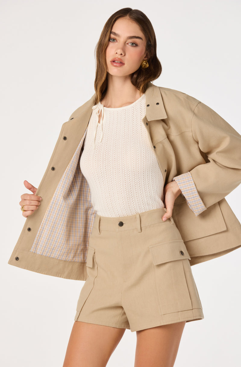 Beige blazer with plaid lining, matching beige shorts, and a cream knit top.