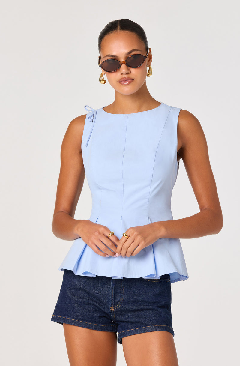 Light blue sleeveless top with a peplum hem and side bow detail, paired with dark denim shorts.