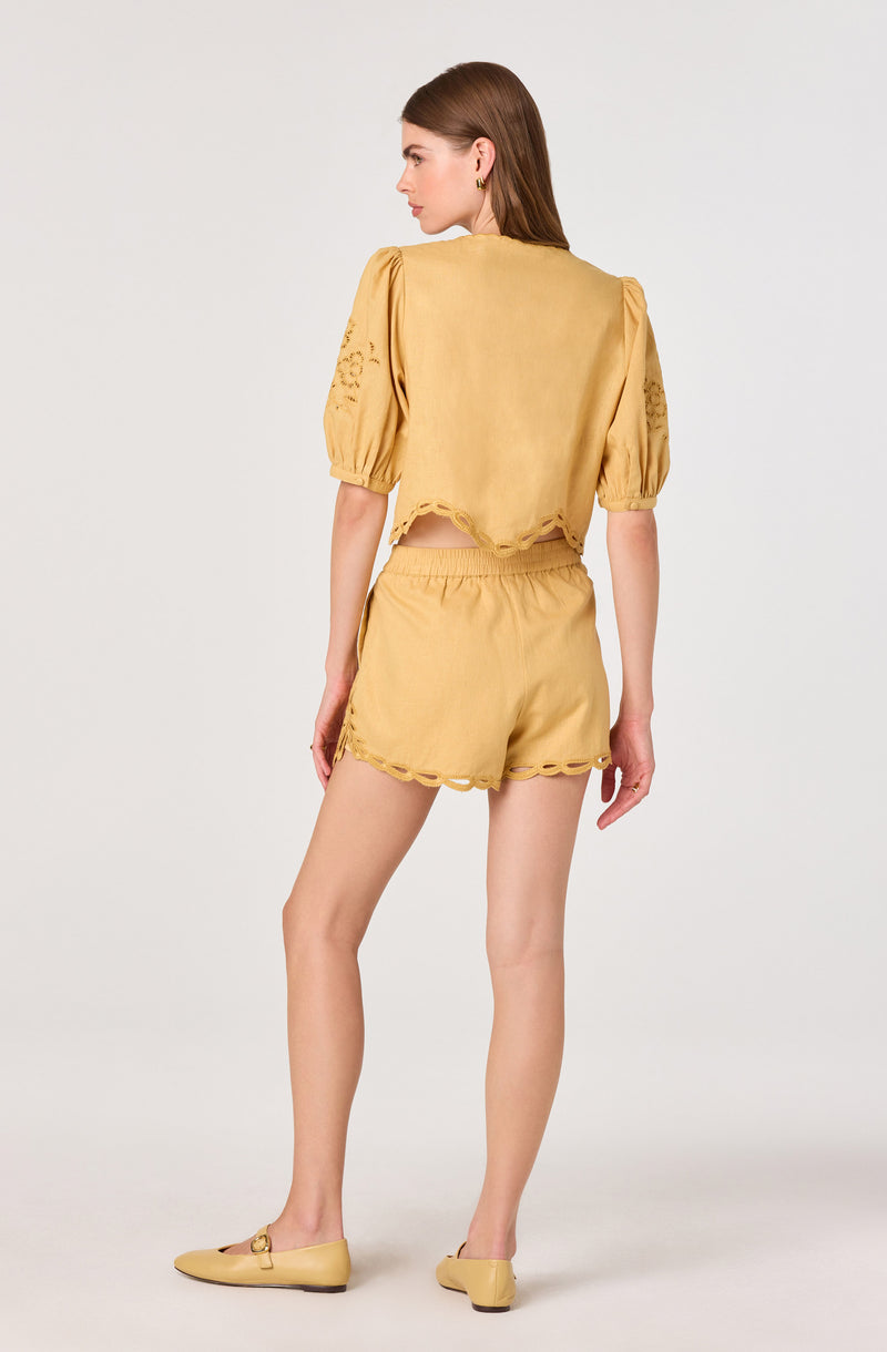 Yellow matching top and shorts with scalloped edges and embroidered sleeve details.