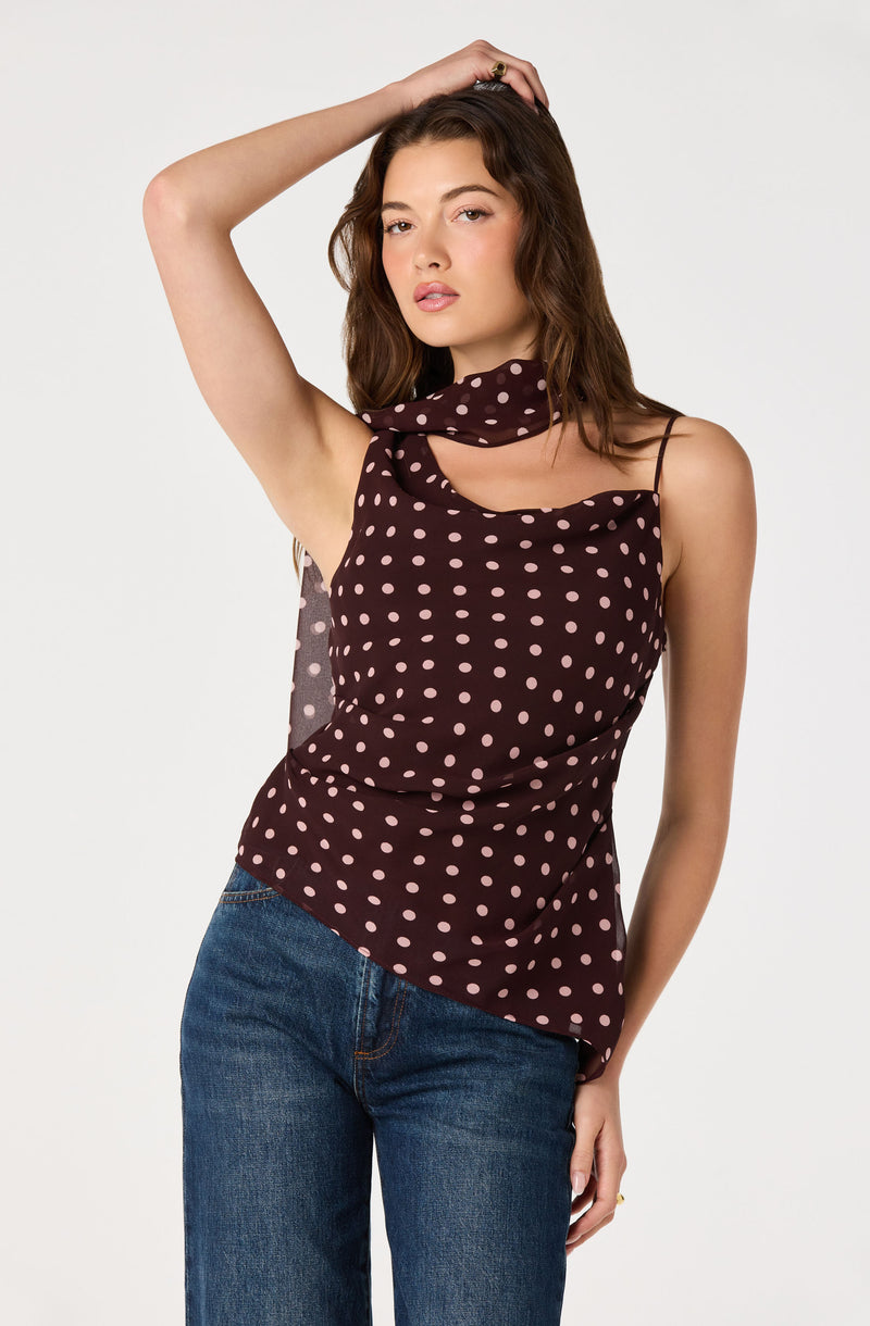 Woman in a brown polka dot sleeveless top with spaghetti straps and a matching scarf.