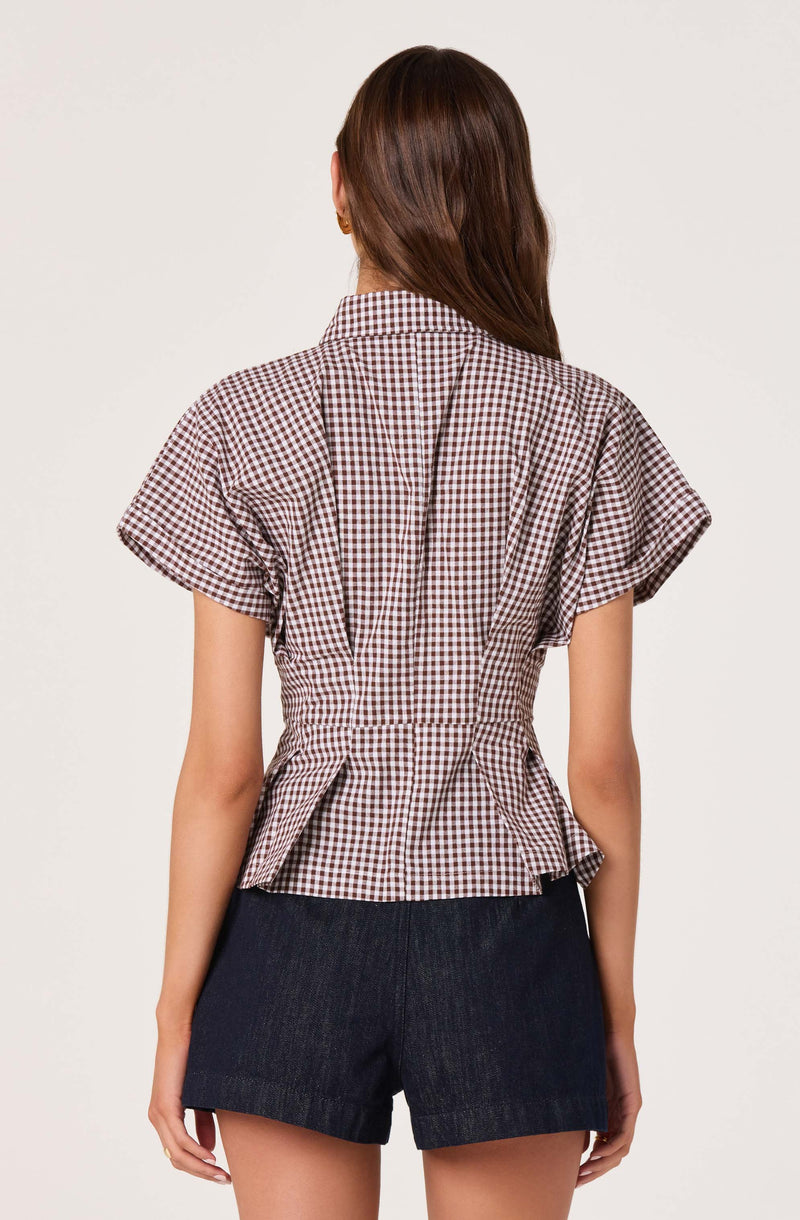Gingham short-sleeve blouse with pleats at the waist, paired with dark denim shorts.