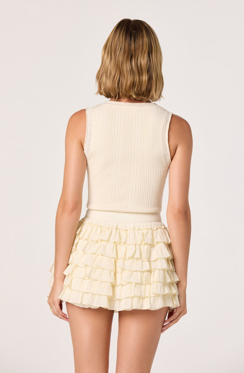Cream sleeveless ribbed top with ruffled cream tiered shorts.