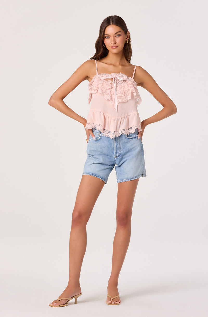 Pink ruffled camisole top with lace details and spaghetti straps, paired with light blue denim shorts.