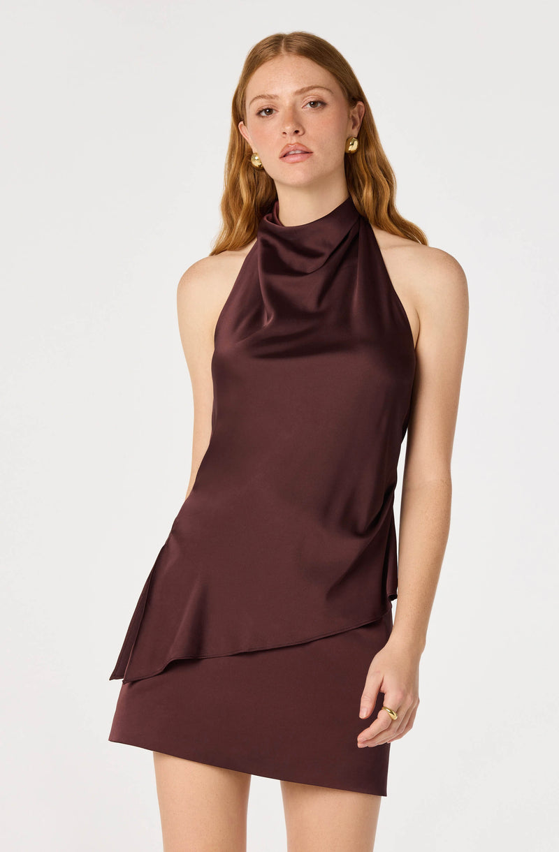 Woman in burgundy satin sleeveless dress with a cowl neck.
