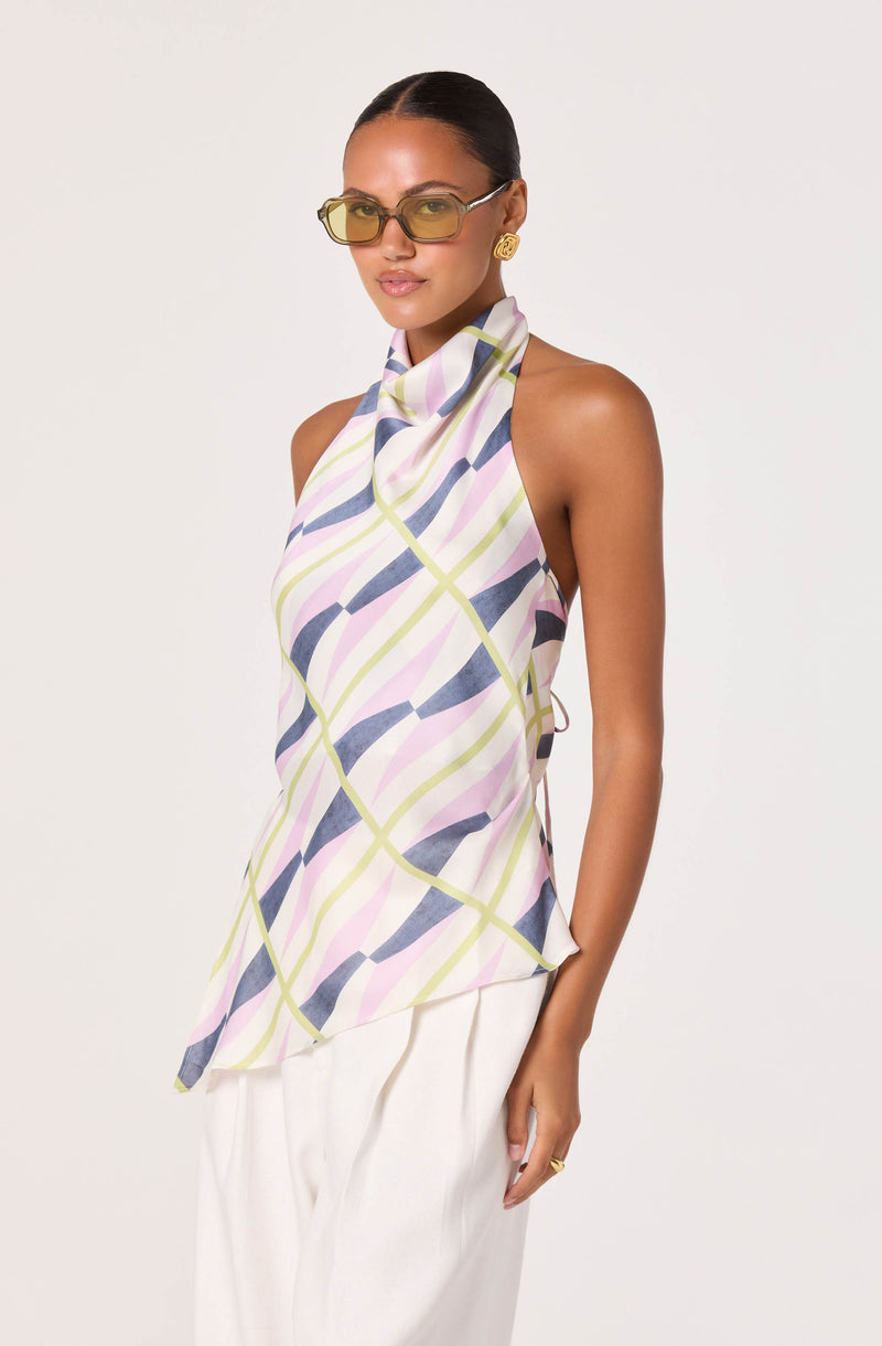 Woman wearing a sleeveless, patterned blouse with pastel colors and a high neck.