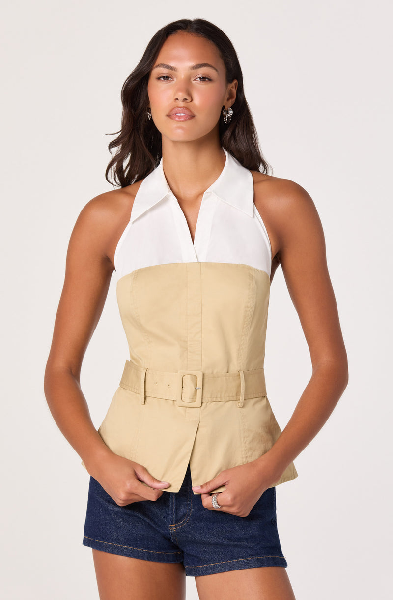 Woman wearing a color-block sleeveless top with a white collar and beige waist with a belt, paired with dark denim shorts.