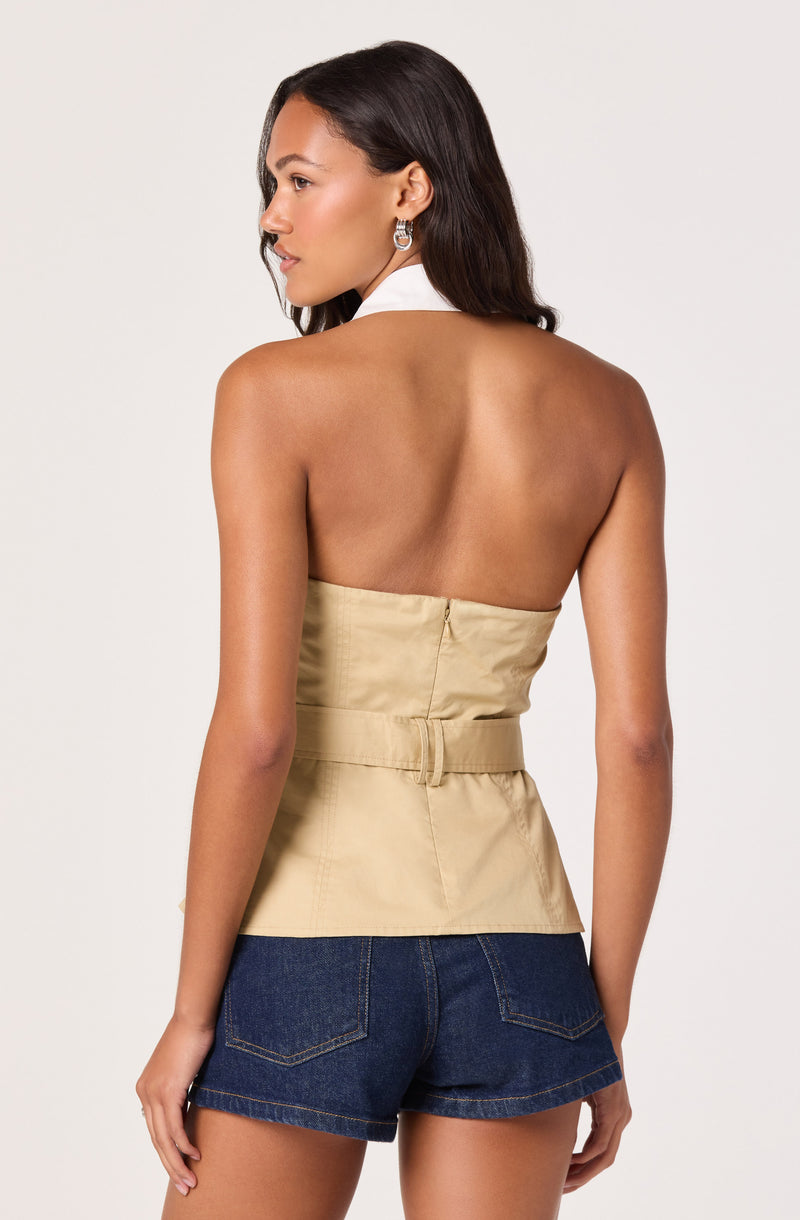Woman in a beige strapless top and dark denim shorts, facing away.