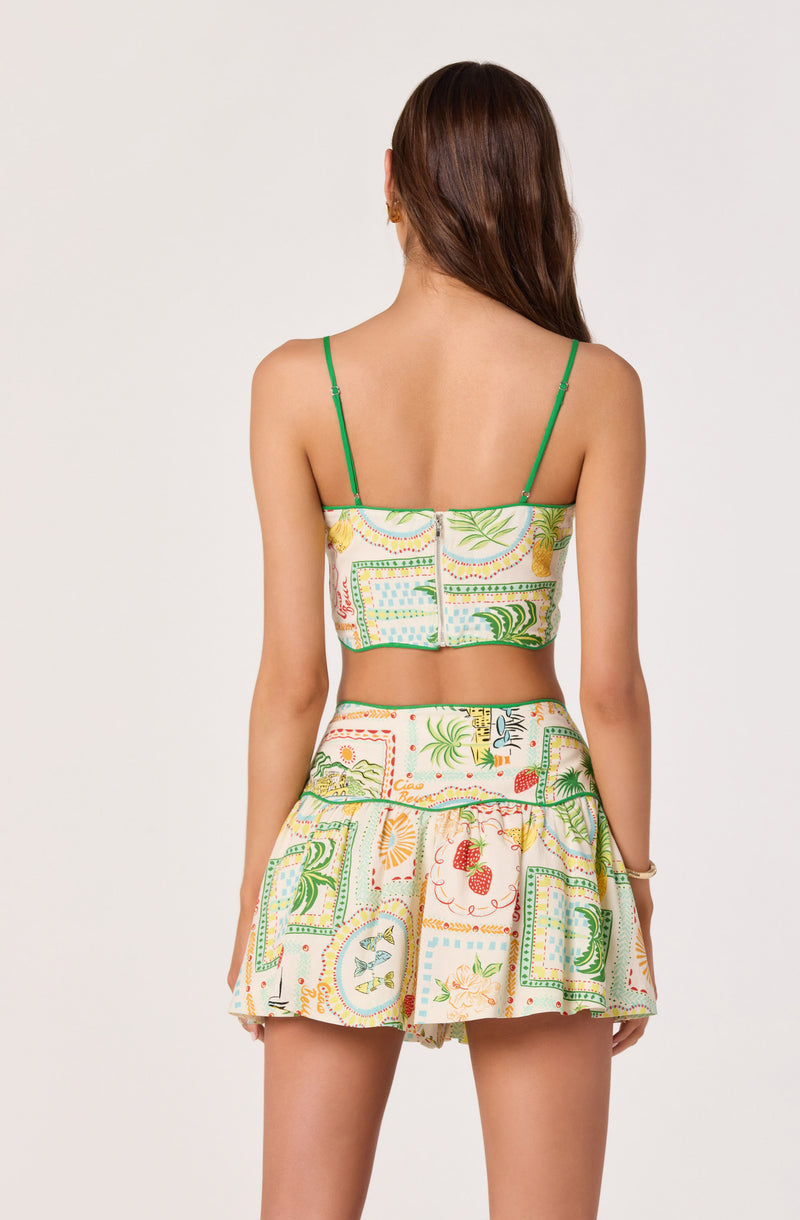 Back view of a woman in a colorful, patterned two-piece outfit with spaghetti straps and a zip closure.
