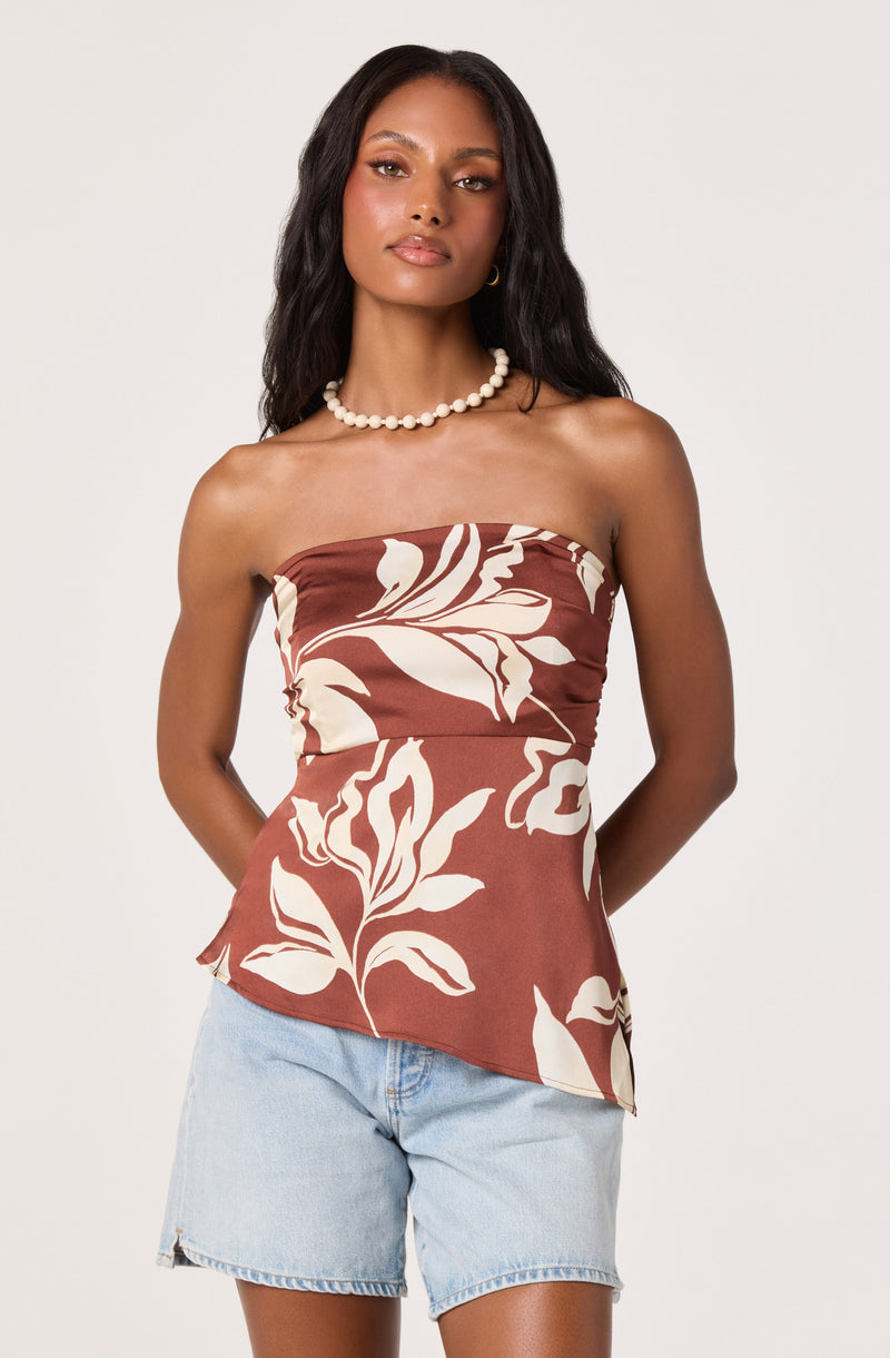 Women wearing a strapless brown top with white floral print and light blue denim shorts.