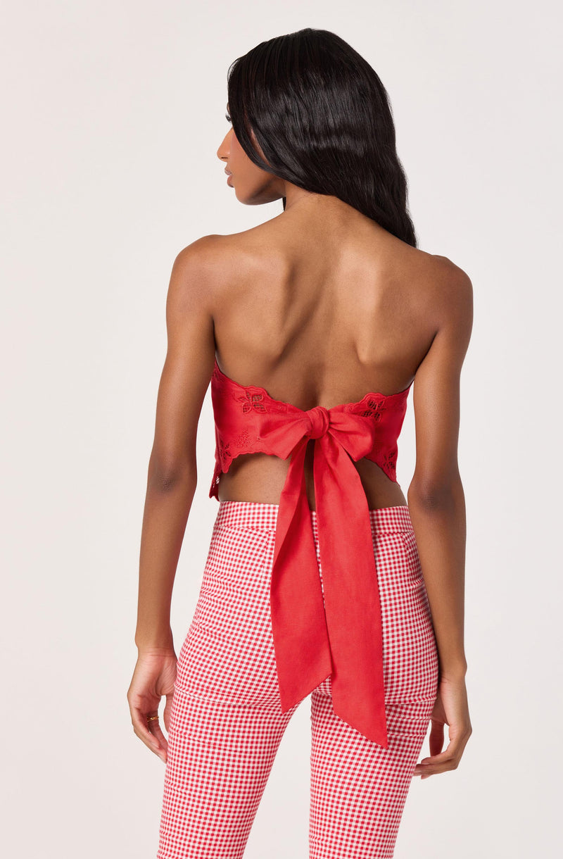 Red strapless top with bow at the back, paired with red and white checkered pants.
