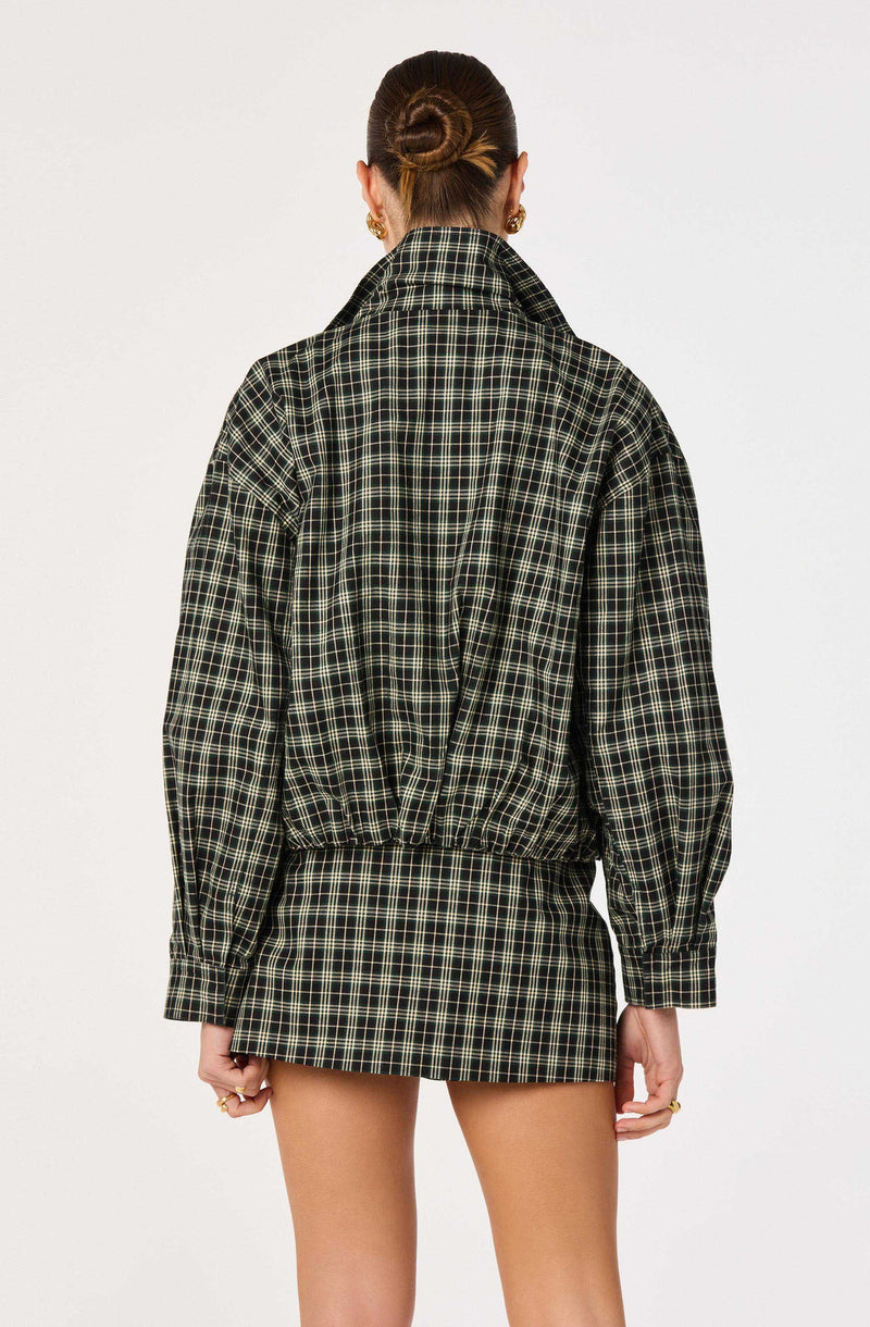 Person wearing a black, green, and beige plaid jacket with elastic waist, paired with a matching plaid skirt.